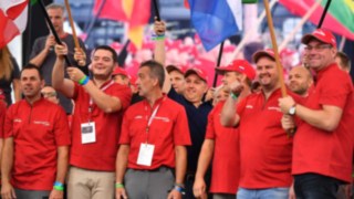 Teilnehmer des NationsCup im Jahr 2019 mit verschiedenen Flaggen in der Hand