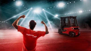 Keyvisual StaplerCup mit Staplerheld in der Arena und Gabelstapler Keyvisual StaplerCup mit Staplerheld in der Arena und Gabelstapler