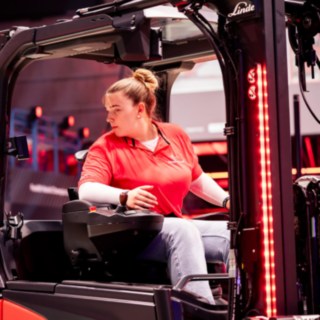 Forklifthero sitzt konzentriert im Stapler und fährt den StaplerCup-Parcours